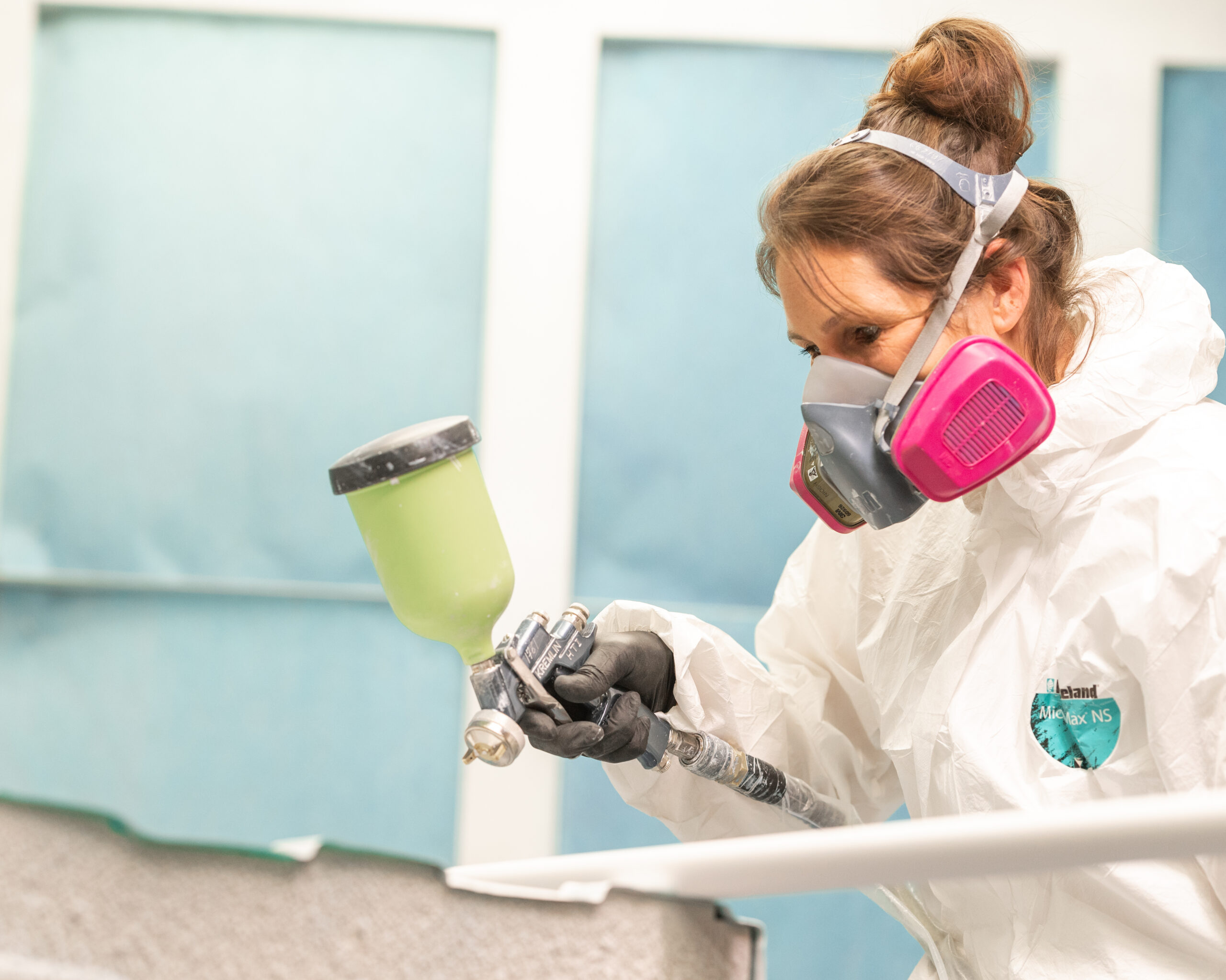 Professionnelle en décontamination pulvérisant un produit sur un objet contaminé