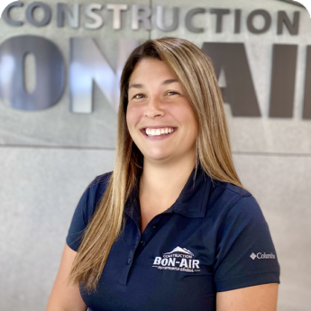 Employée de Construction Bon-Air souriante devant le logo