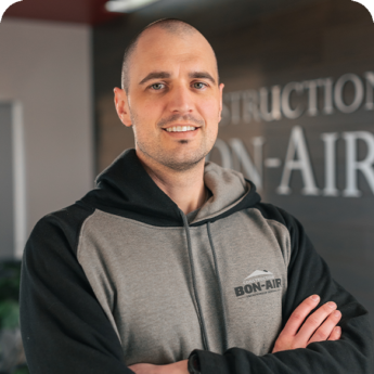 Employé de Construction Bon-Air posant devant le logo